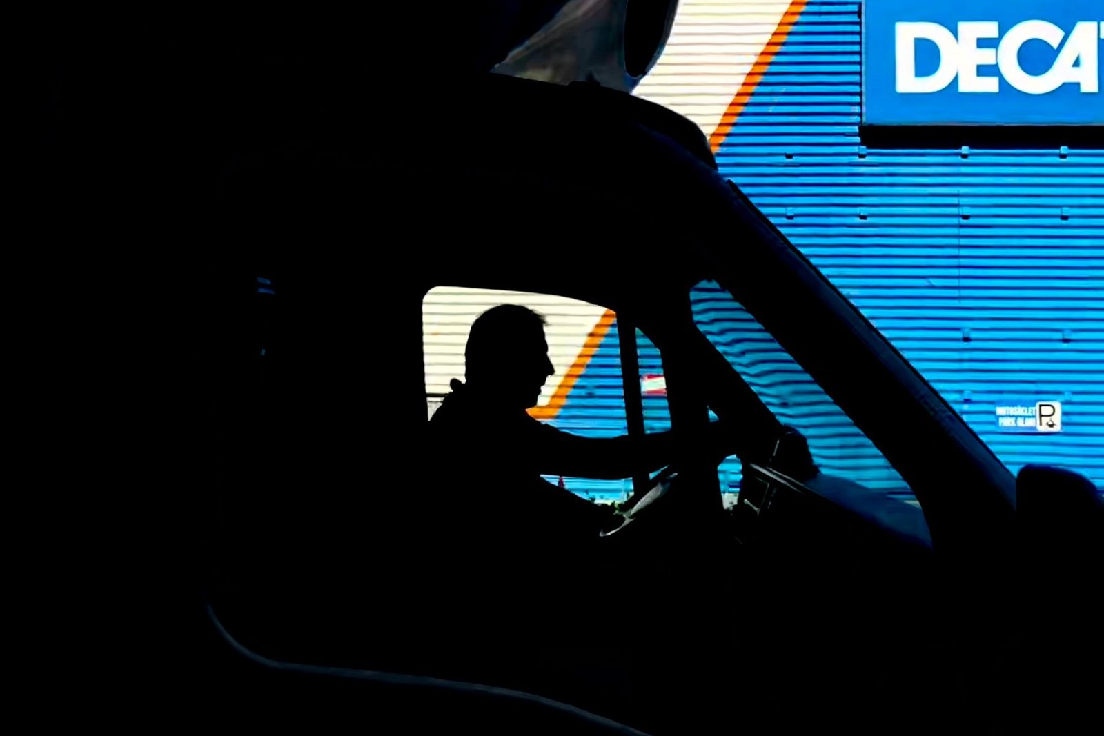 Silhouette of a truck driver at the wheel at night