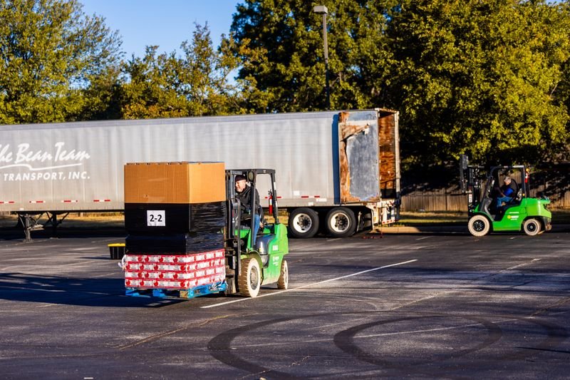 Forklift loading pallets into a semi-trailer at a dock