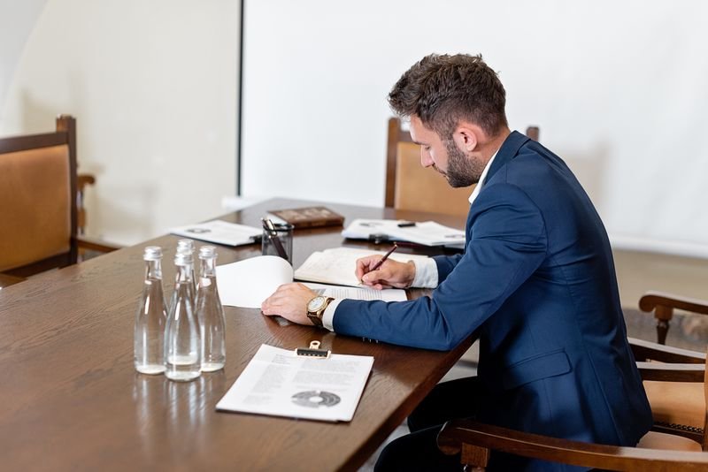 Dispatcher reviewing and signing load paperwork at a desk
